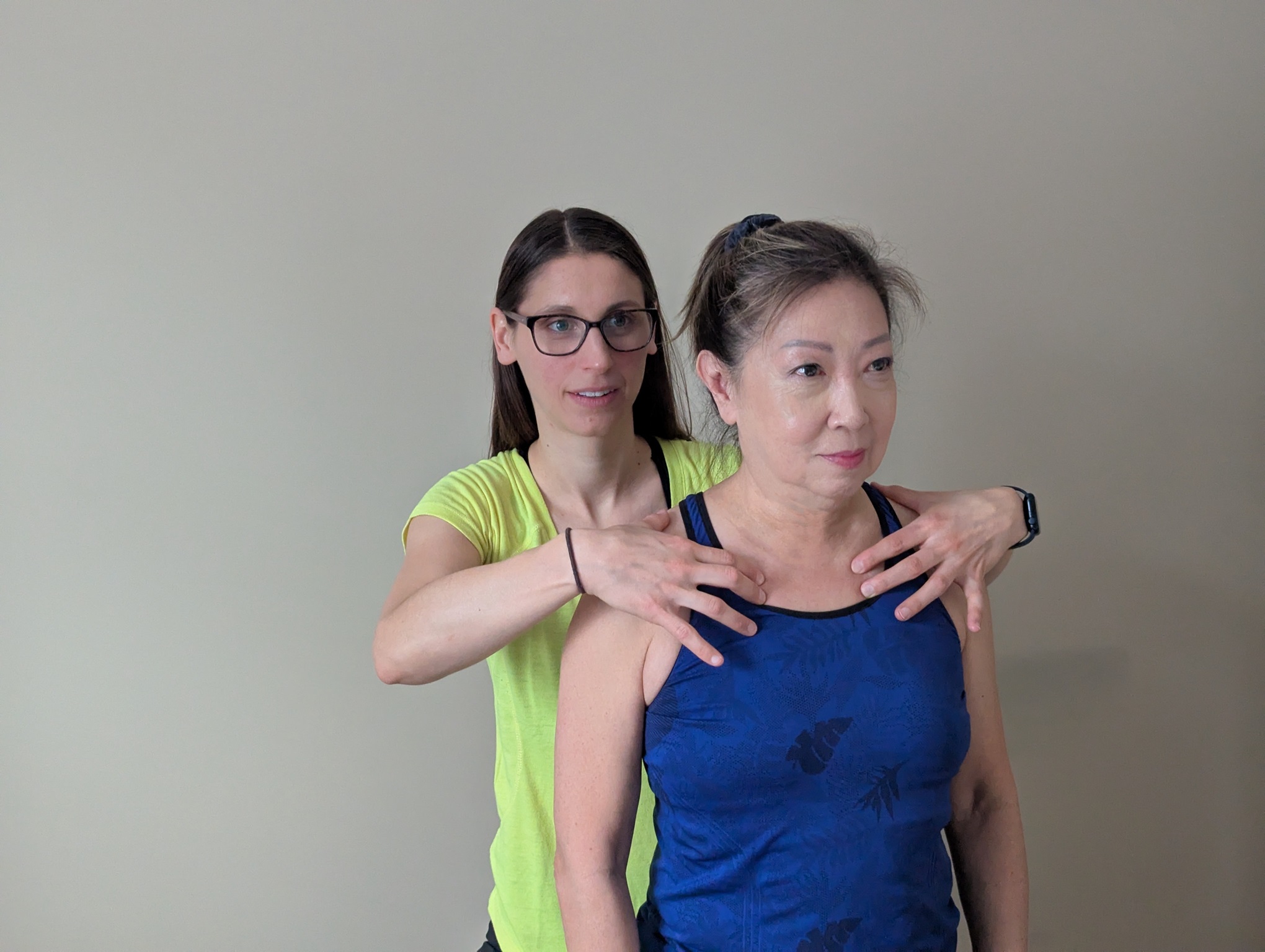 A physiotherapist evaluates the position of a patient's second rib, using gentle manual techniques to assess alignment and mobility.
