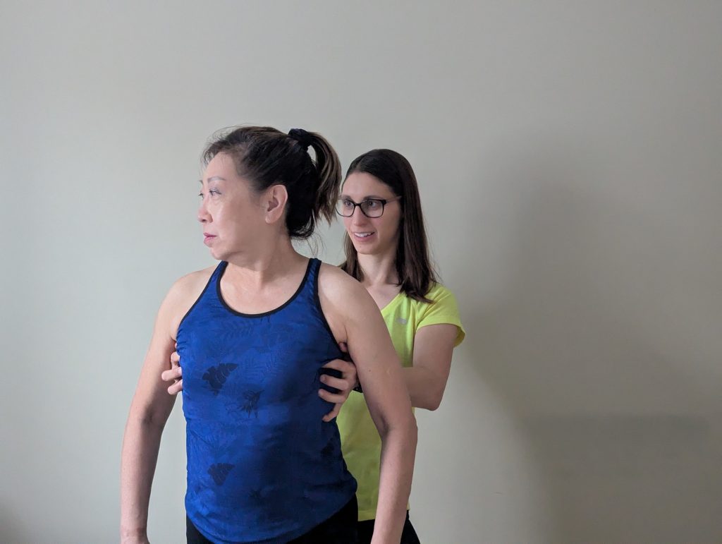 A physiotherapist corrects a patient’s thorax and assesses the effect of the thorax correction on the patient’s cervical spine range of motion.